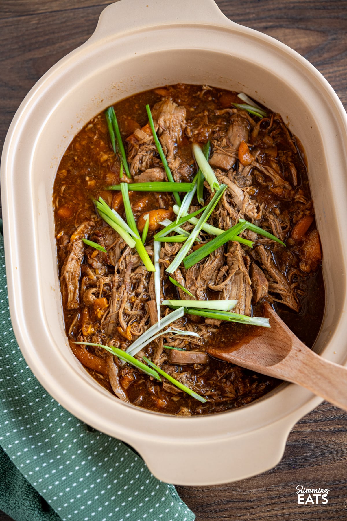 Slow Cooker Ginger Peach Pork cooked in magnique claypot cooker with wooden spoon place in pot
