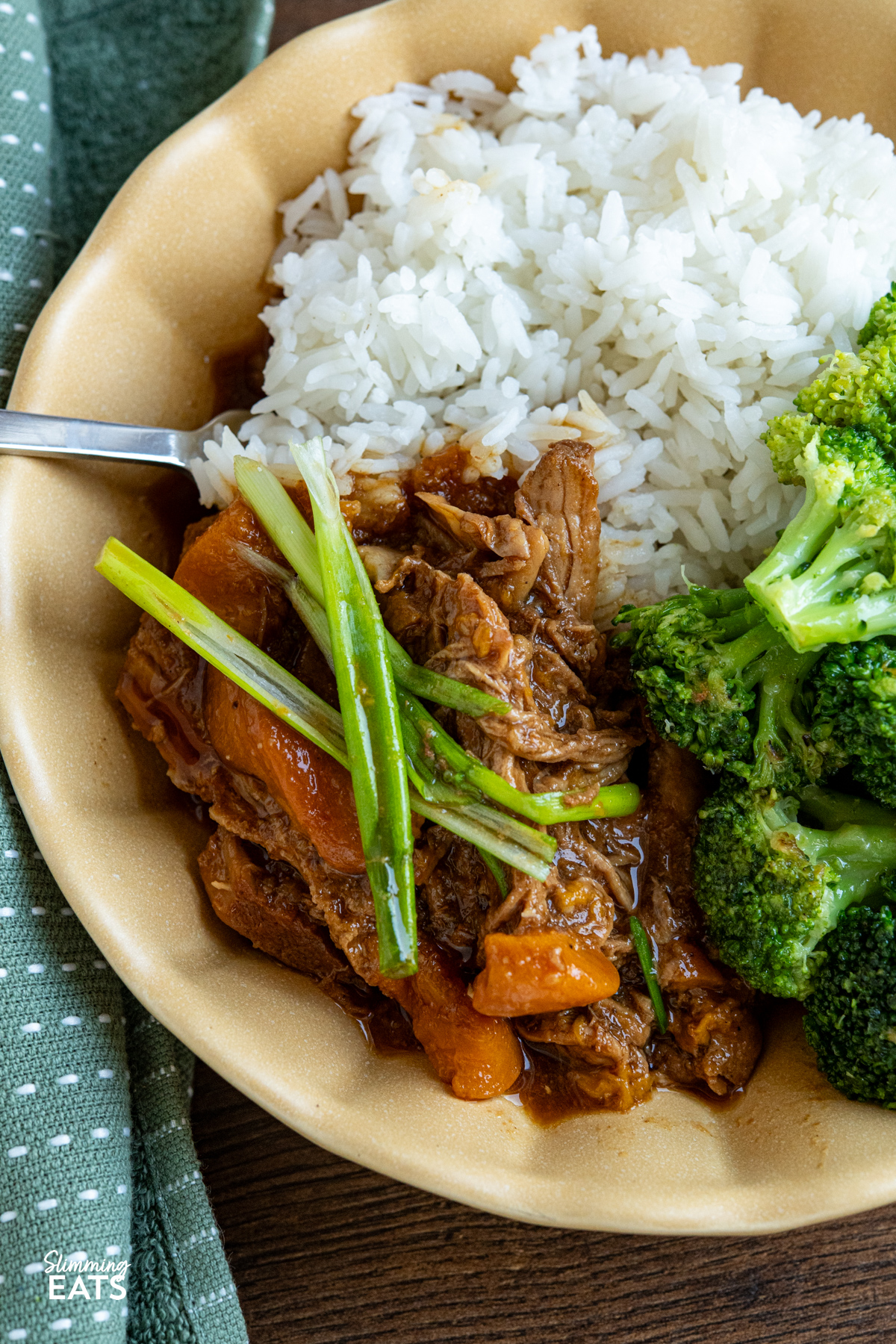 cooked Slow Cooker Ginger Peach Pork in a yellow bowl served with rice and steamed broccoli 