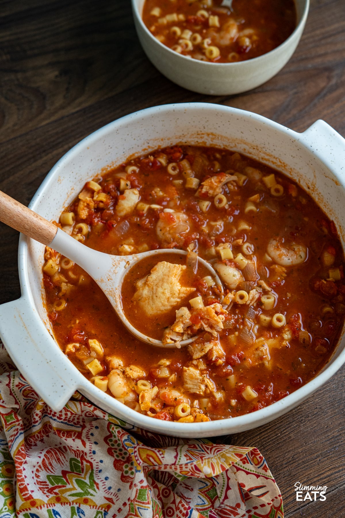A rich and hearty Mediterranean-inspired seafood pasta soup made with monkfish, shrimp and tender ditalini in a deeply flavourful tomato broth. Fish and Pasta Soup in a white casserole pot with ladle