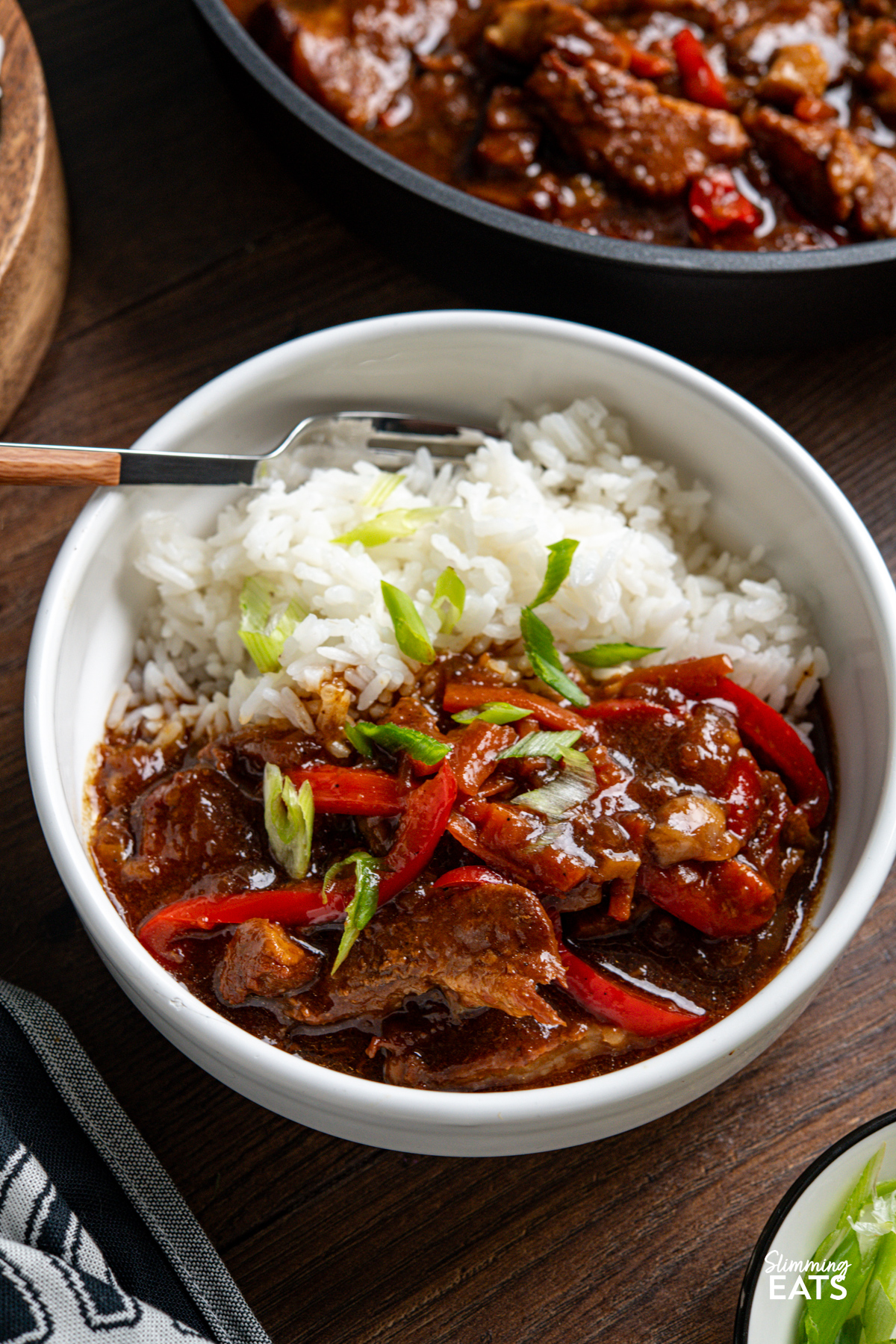 close up of serving of Slow Cooker Honey Tamarind Pork in white bowl with white rice with fork placed in bowl