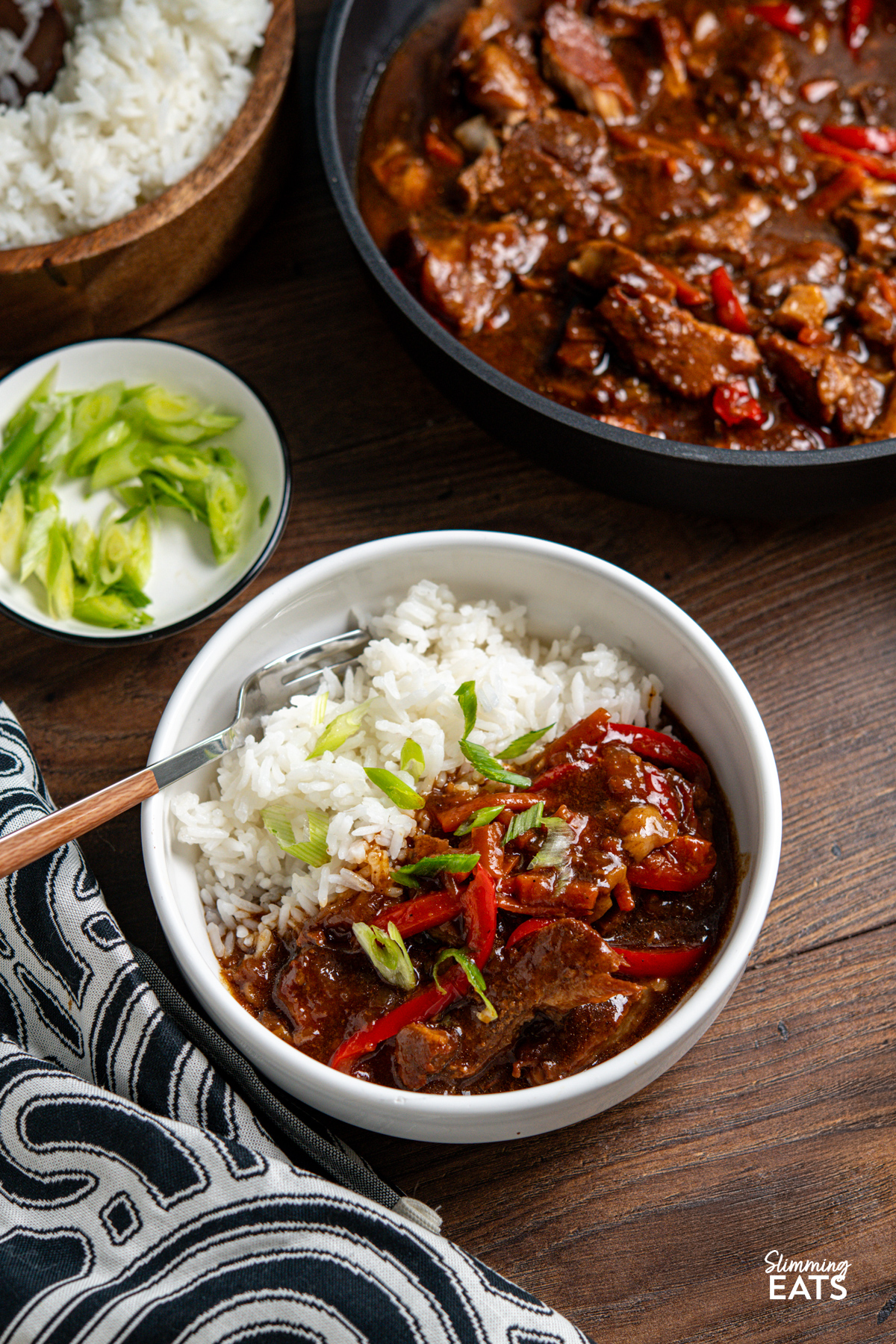 serving of Slow Cooker Honey Tamarind Pork in white bowl with white rice with fork placed in bowl