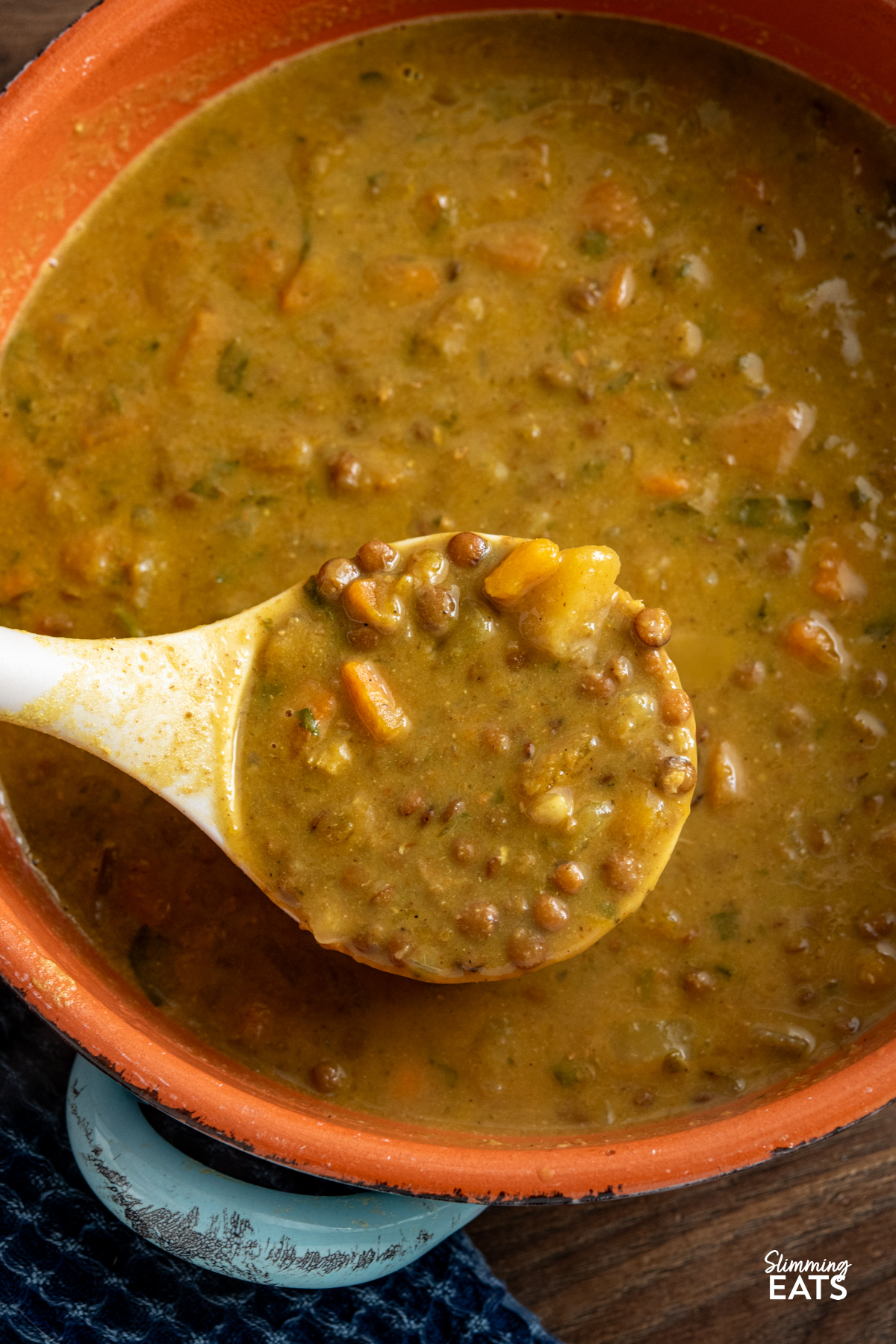 Slow Cooker Coconut Lentil Soup in a ceramic dish with ladle