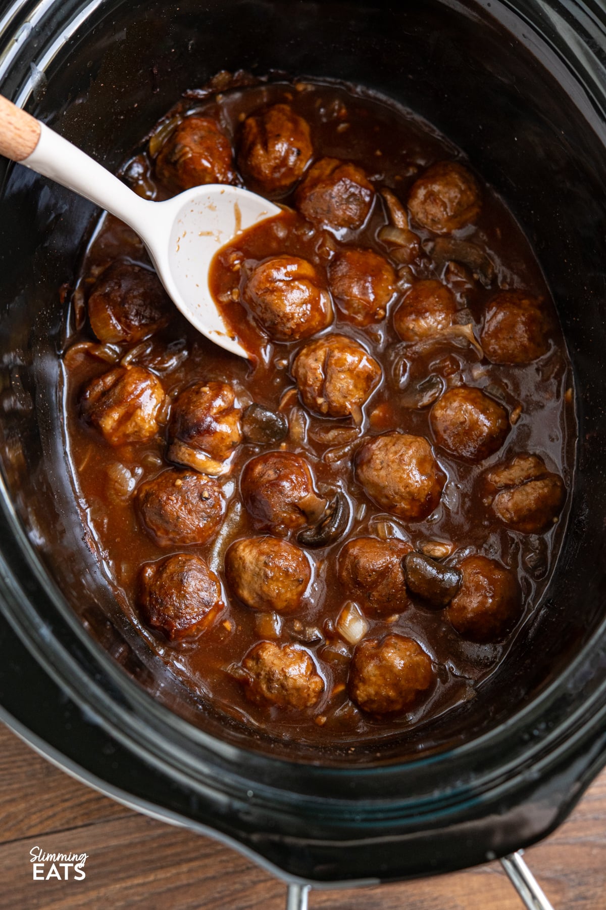 These slow cooker Salisbury meatballs are an easy, hearty dinner made with frozen meatballs simmered in a rich onion and mushroom gravy. Salisbury Meatballs in slow cooker with spoon
