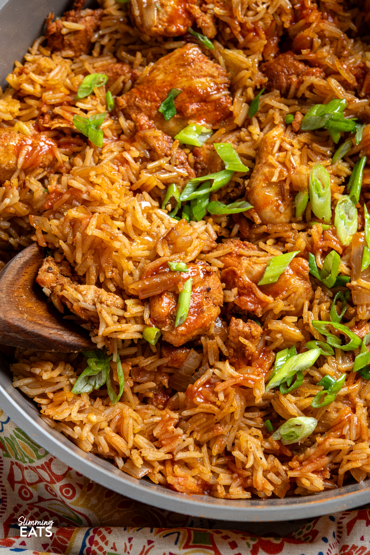 close up of One Pan Nashville Chicken and Rice in a yellow ceramic non stick pan with wooden spoon