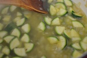 onion, garlic and zucchini in stock in a pan