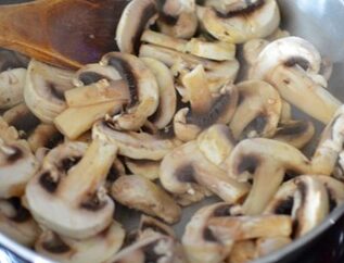 mushrooms and garlic being sauteed in a pan