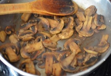 golden sauteed mushrooms and garlic in a pan