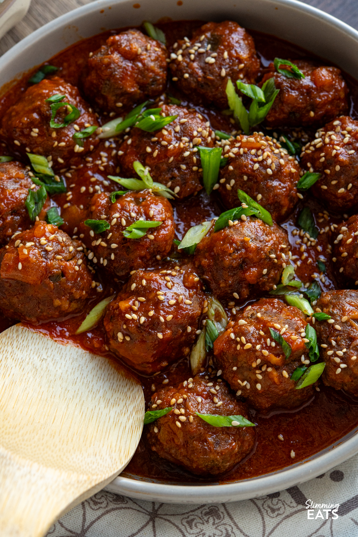 close up of pork meatballs in gochujang pineapple sauce in a beige bowl